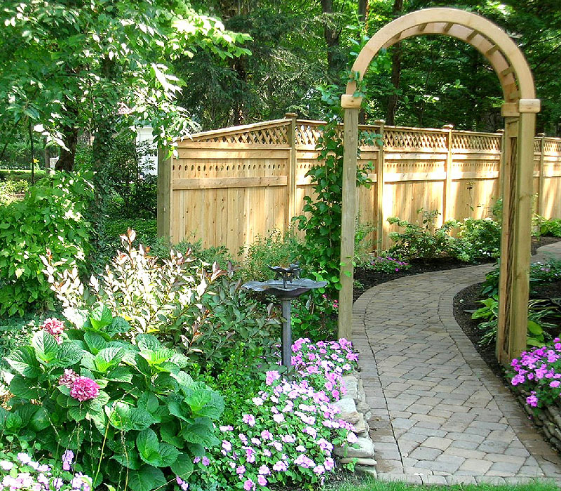 wood arbor with wood privacy fence by Elyria Fence