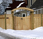 wood arbor with a gate and semi private wood fence by elyria fence