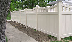 Vinyl privacy fence with scalloped spindle lattice by Elyria Fence